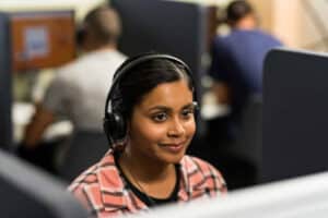 IELTS Computer Delivered test taker in Canada with headset onin testing hall.